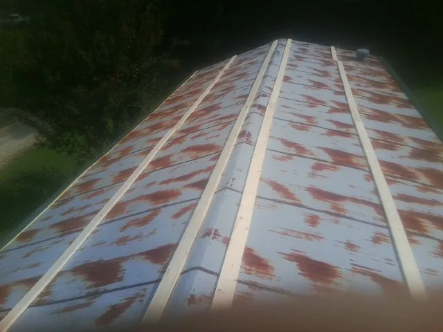 Rusted metal roof panels with new wood purlins before replacement — Storm Damage Roof Repair in Cana by Roofing Brothers