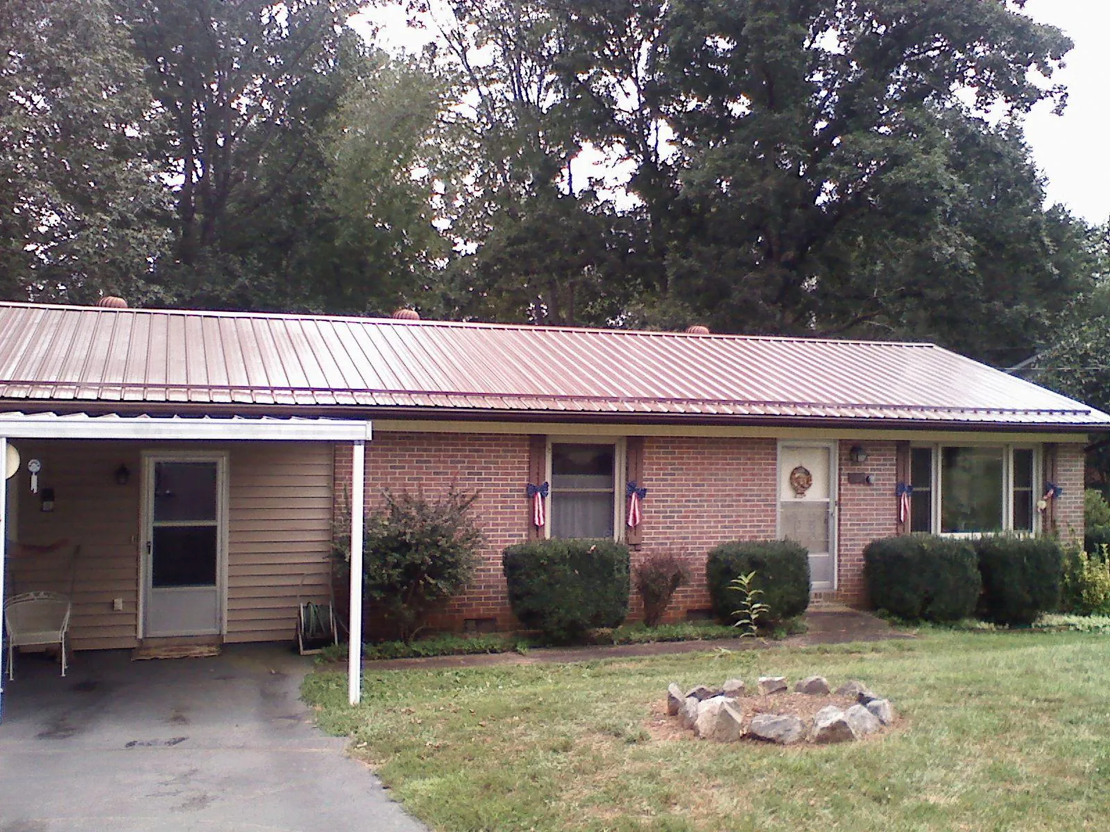 Bronze metal roof and carport on a brick ranch home — Roof Repair work by our crew in Cana