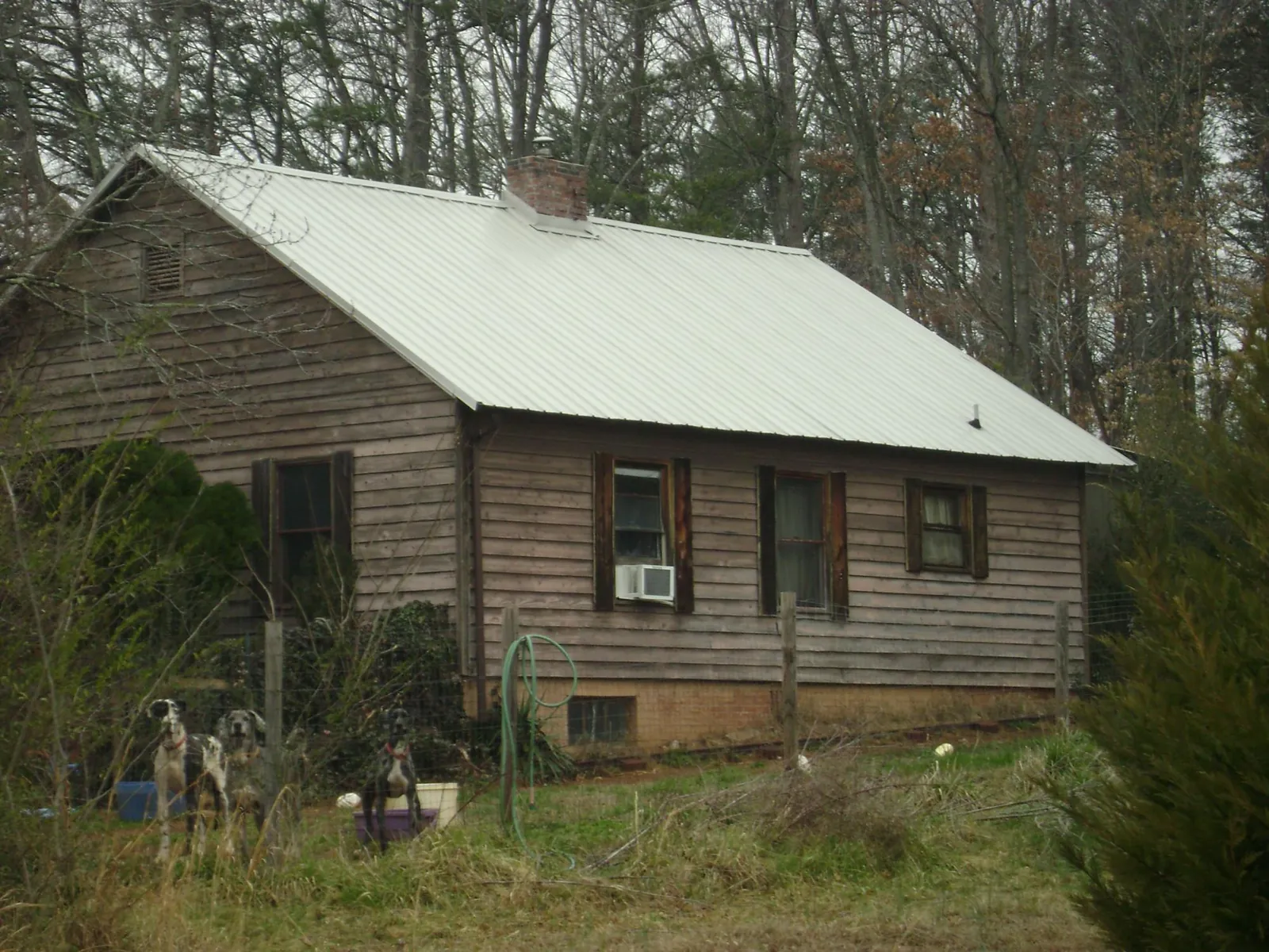 White metal roof on an old wood sided farmhouse, from a Metal Roof Installation job in Cana